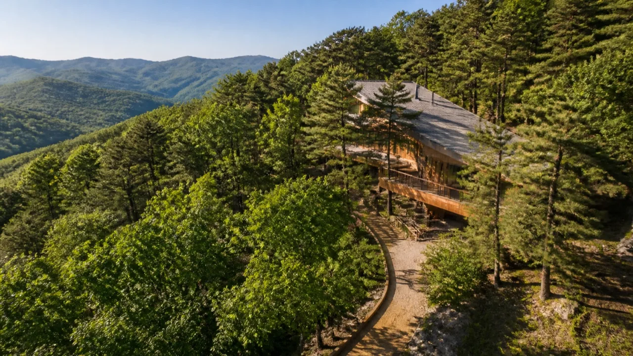 푸른 산맥과 울창한 숲속에 자리 잡은 국립진안고원산림치유원 친환경 목조 건물들의 전체적인 전경